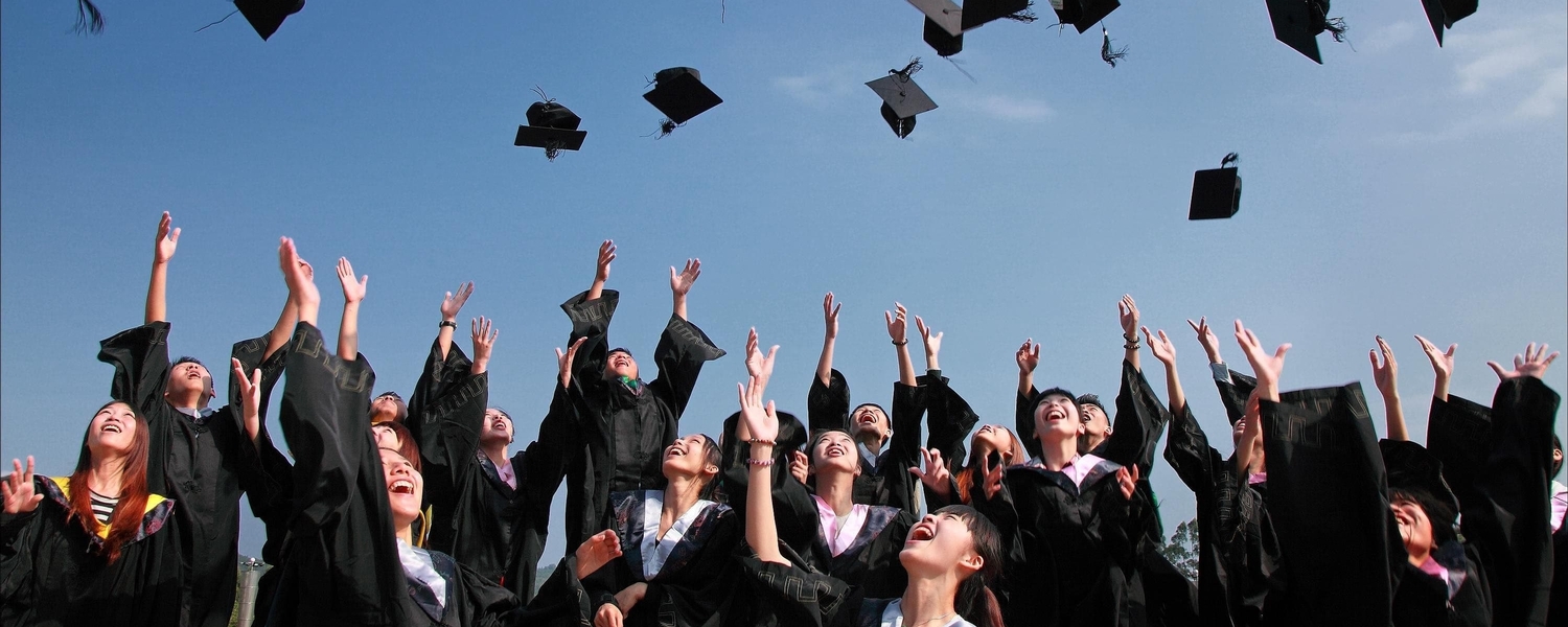 graduates tossing caps